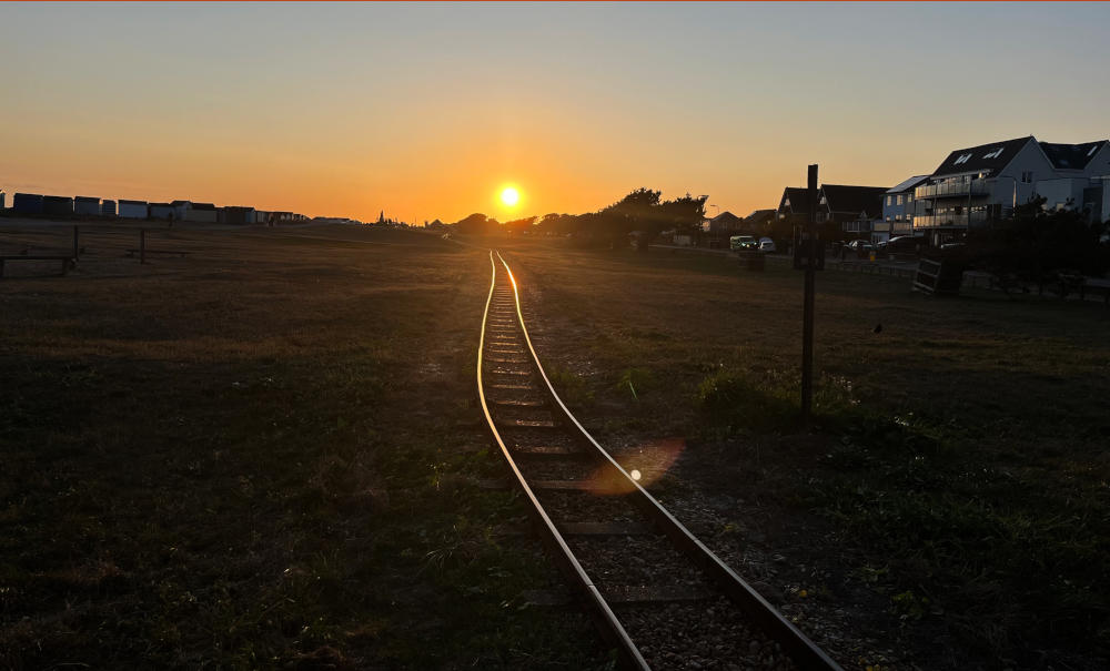 Lines of a miniature railway reflecting the setting sun