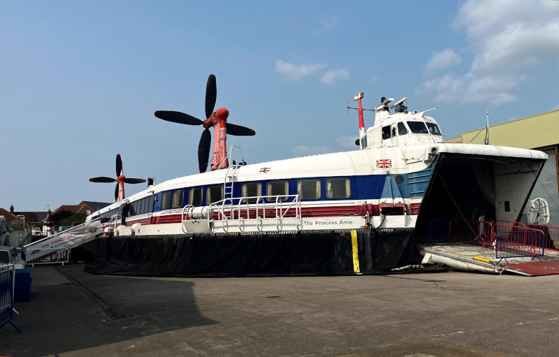 A large hovercraft on a concrete open space, with its bow door - once giving access for cars - wide open