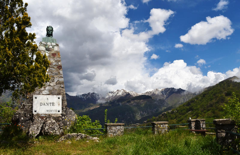 A monument to Dante Alighieri with distant mountains behind