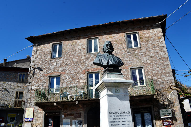 Looking up at a statue of Giuseppe Garibaldi, with a traditional building behind