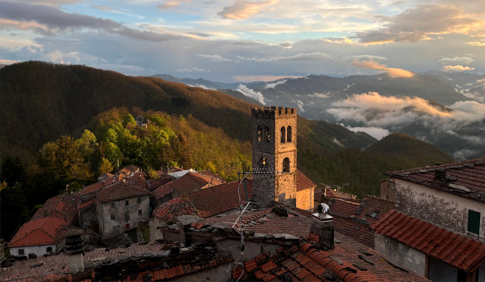 View over a church tower and distant mountains in evening sunshine